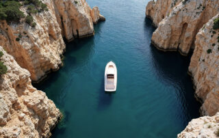 Private yacht cruising between the volcanic cliffs of the Santorini caldera